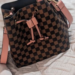 Brown checkered print handbag with pink accents and gold hardware